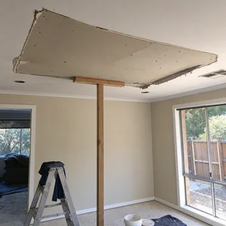 Residential ceiling with a sagging plasterboard section being repaired