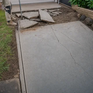 Old cracked concrete driveway being cut and broken out for replacement