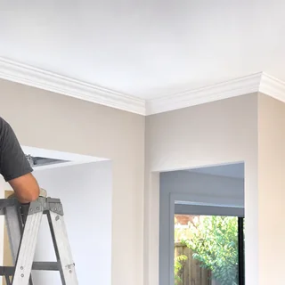 Freshly installed white cornice along a wall and ceiling join