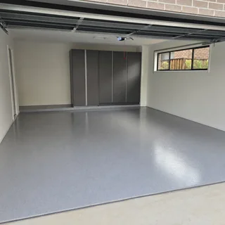 Grey epoxy coated residential garage floor with a clean gloss finish