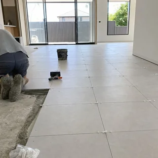 Large format porcelain tiles laid across an open plan living room floor