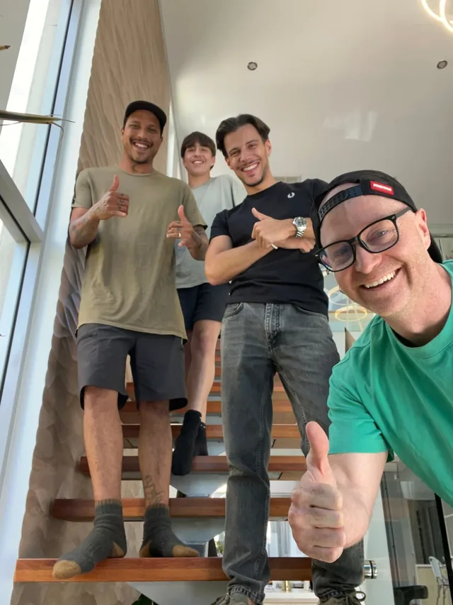 Levi Saunders taking a selfie with three people on a timber staircase, everyone smiling and giving a thumbs up.