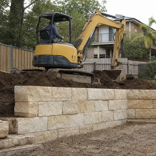 Excavated batter behind a partly built limestone retaining wall