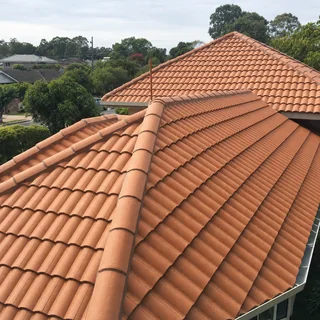 Tile roof part way through a restoration, half cleaned and half recoated