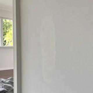 Repaired patch of plaster over a crack on an interior wall